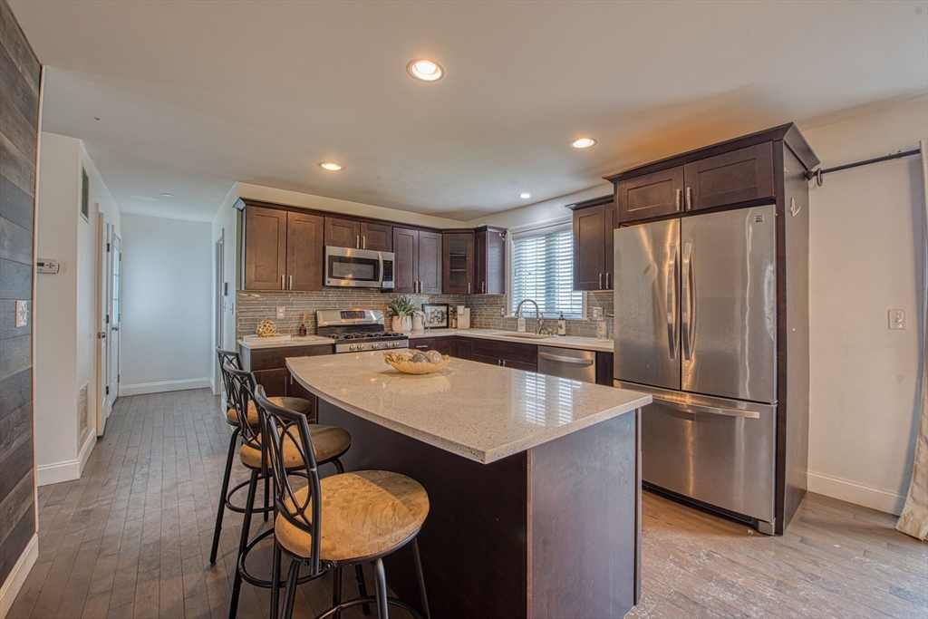 438 Smith Street Fall River, MA 02721 - Photo 6 of 31 a kitchen with stainless steel appliances granite countertop a refrigerator a sink a stove a dining table and chairs