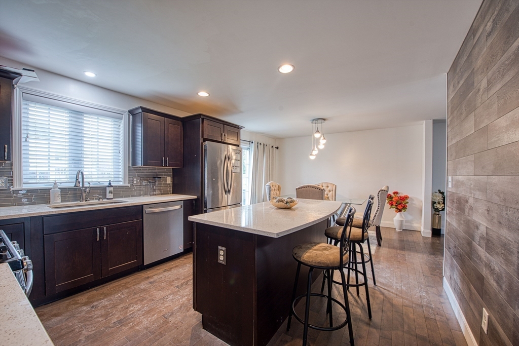 438 Smith Street Fall River, MA 02721 - Photo 7 of 31 a kitchen with stainless steel appliances granite countertop a table chairs sink refrigerator and granite counter tops