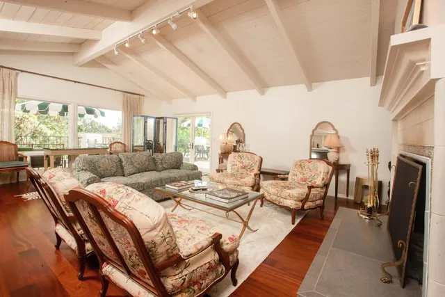 a living room with furniture a fireplace and a floor to ceiling window