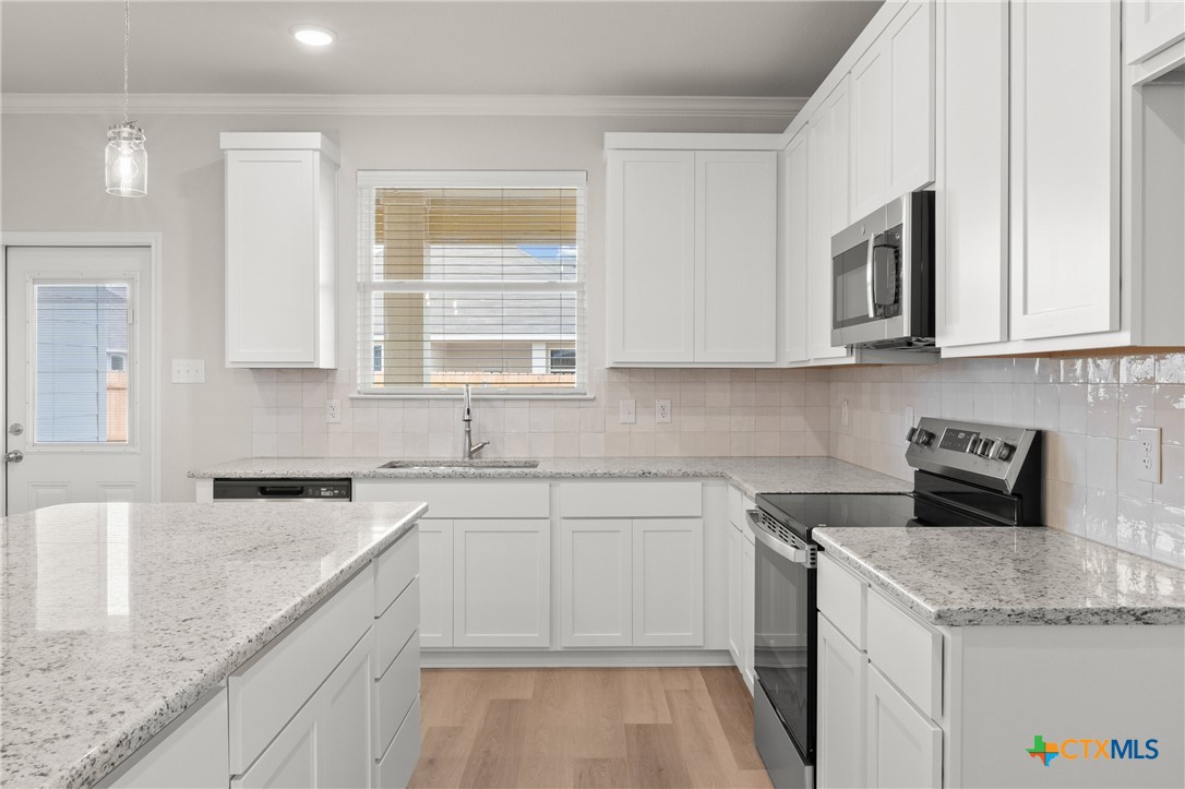 8024 Pineridge Way Temple, TX 76502 - Photo 13 of 32 a kitchen with stainless steel appliances granite countertop a sink stove and microwave