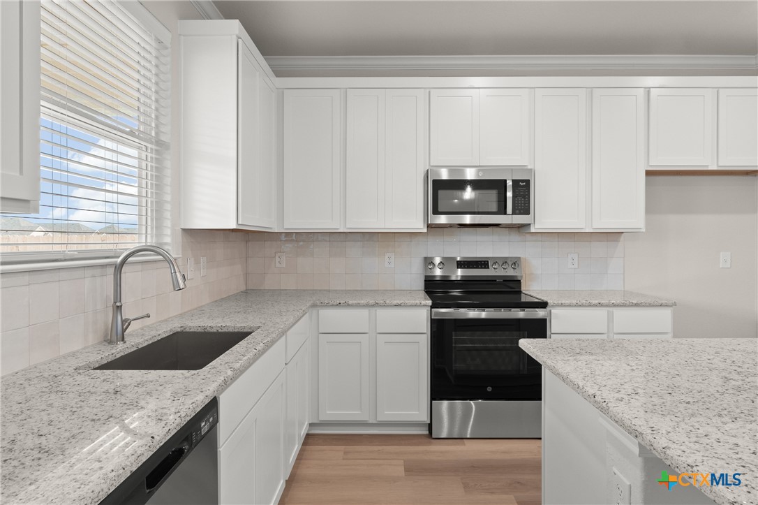 8024 Pineridge Way Temple, TX 76502 - Photo 14 of 32 a kitchen with granite countertop a sink stove and microwave