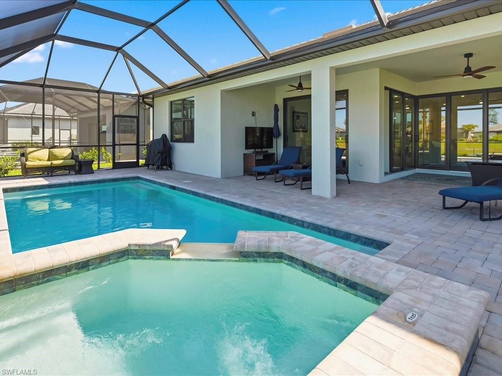 1937 Don Benito Way Naples, FL 34120 - Photo 11 of 27 View of swimming pool featuring glass enclosure, a sunroom, ceiling fan, and a pool with connected hot tub