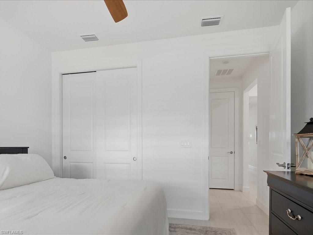1937 Don Benito Way Naples, FL 34120 - Photo 18 of 27 Bedroom with a closet, light tile patterned floors, and a ceiling fan