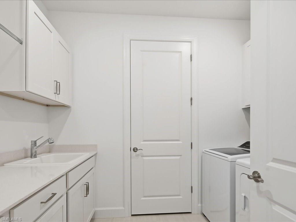 1937 Don Benito Way Naples, FL 34120 - Photo 23 of 27 Laundry area with cabinet space and washing machine and clothes dryer