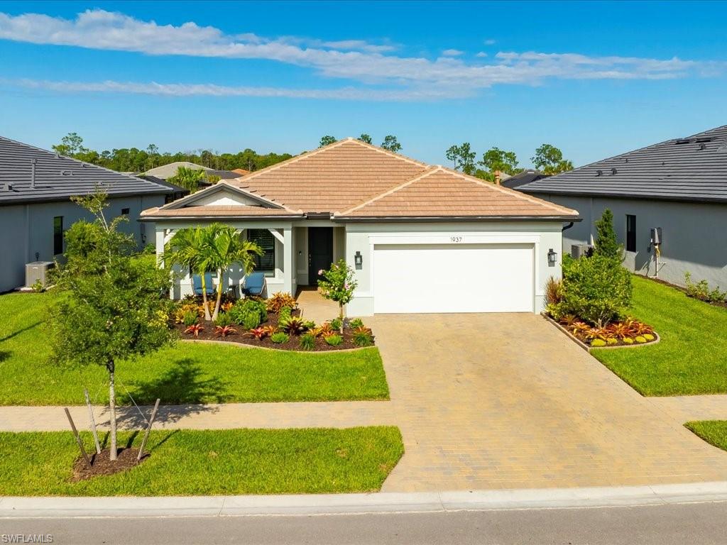 1937 Don Benito Way Naples, FL 34120 - Photo 3 of 27 Ranch-style house with decorative driveway, a garage, a front lawn, stucco siding, and a porch