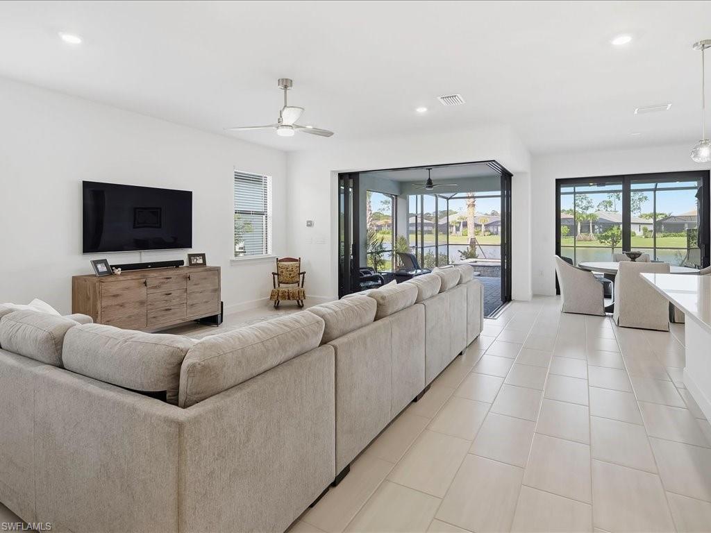 1937 Don Benito Way Naples, FL 34120 - Photo 4 of 27 Living area featuring recessed lighting, healthy amount of natural light, light tile patterned flooring, a ceiling fan, and a water view