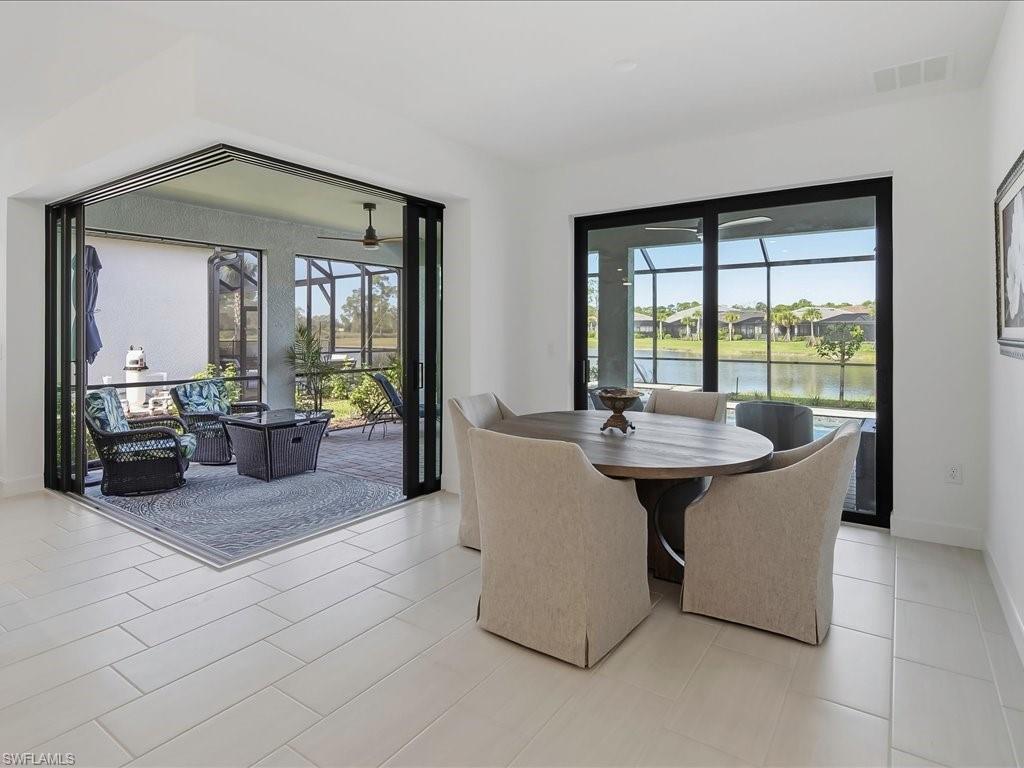 1937 Don Benito Way Naples, FL 34120 - Photo 8 of 27 Dining area featuring a sunroom, a water view, and light tile patterned floors