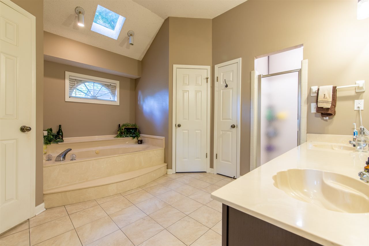 7758 Grey Squirrel Cove Memphis, TN 38018 - Photo 15 of 22 Master Bathroom features his and hers closets, double vanities, and jacuzzi tub with separate shower.