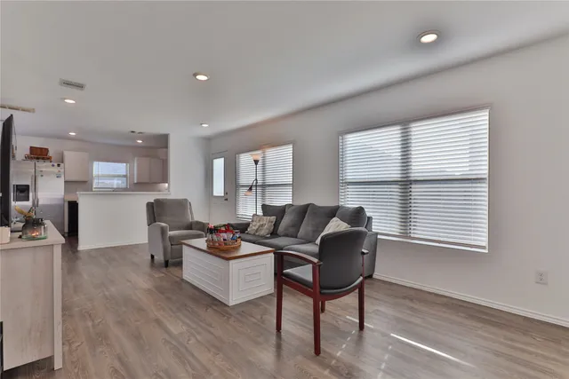 a living room with furniture and a wooden floor