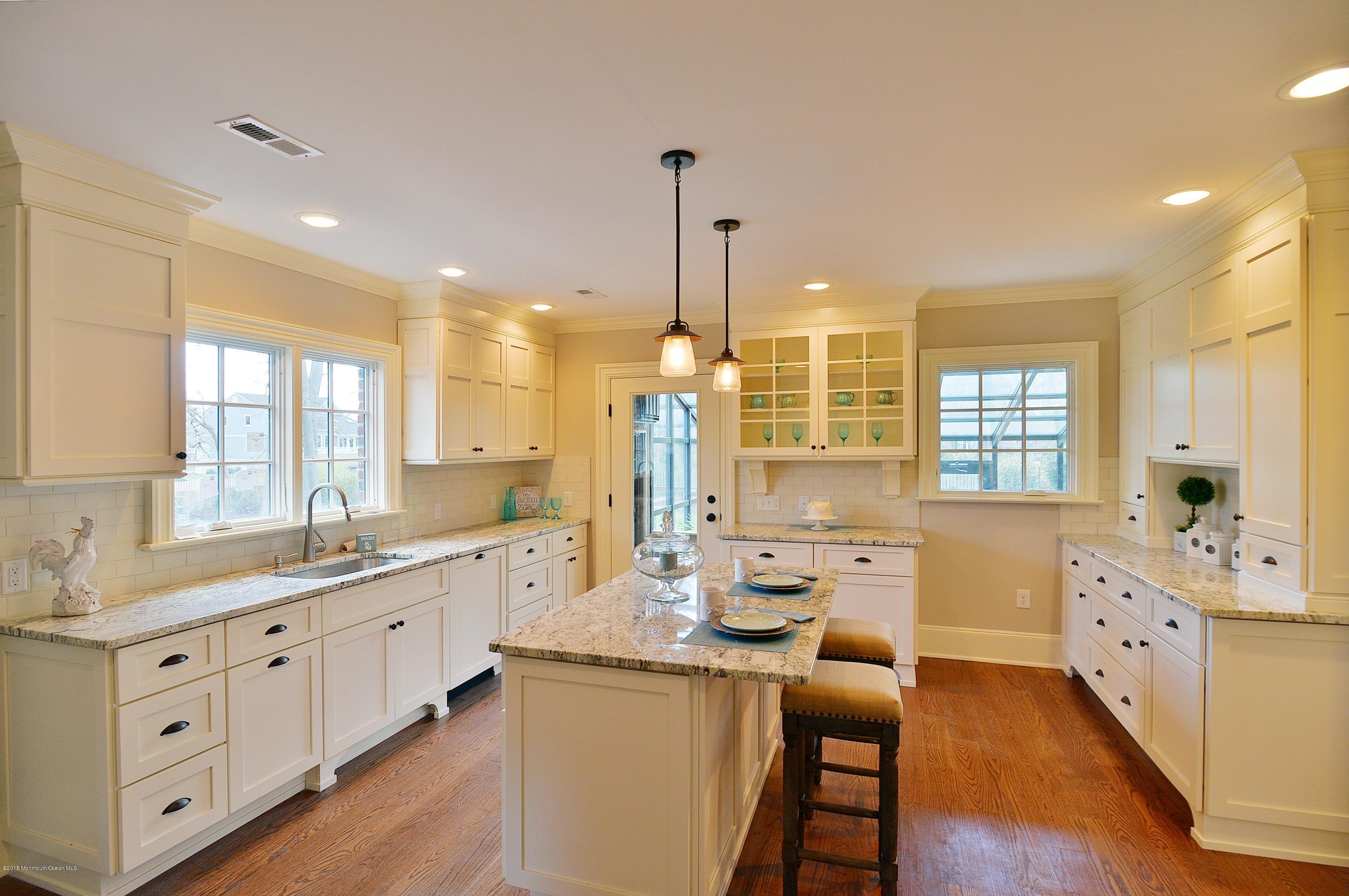 38 Silverside Avenue Little Silver, NJ 07739 - Photo 15 of 36 a large kitchen with kitchen island white cabinets and wooden floors
