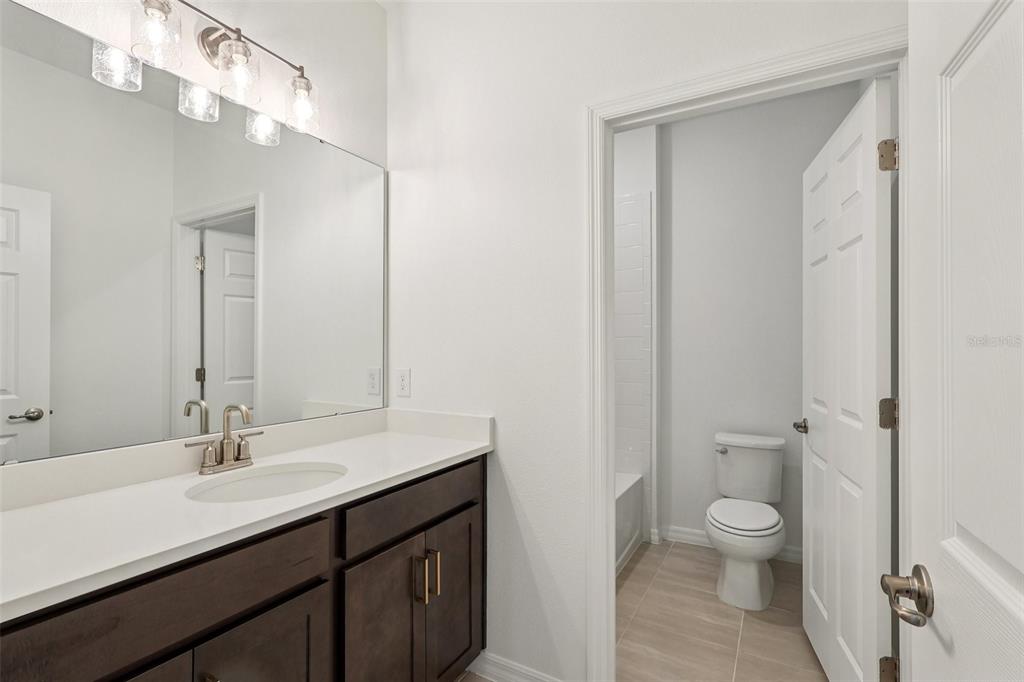 1756 Columbus Path St. Cloud, FL 34771 - Photo 16 of 37 a bathroom with a sink a toilet a light fixture and a mirror
