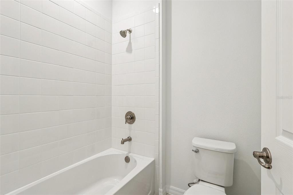 1756 Columbus Path St. Cloud, FL 34771 - Photo 17 of 37 a bathroom with a bathtub and a toilet