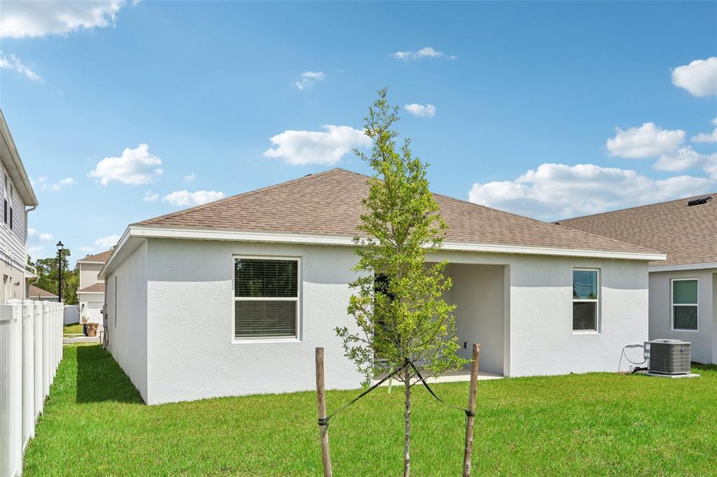 1756 Columbus Path St. Cloud, FL 34771 - Photo 30 of 37 a front view of a house with a yard and trees