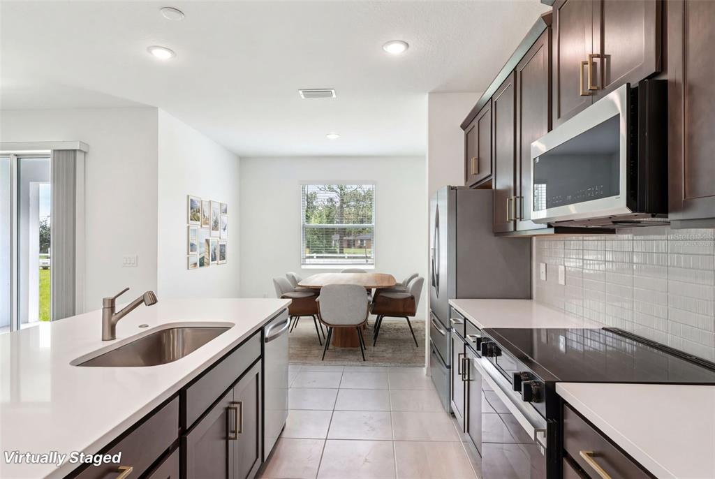1756 Columbus Path St. Cloud, FL 34771 - Photo 5 of 37 a kitchen with granite countertop a sink and a stove top oven