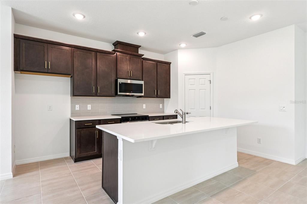 1756 Columbus Path St. Cloud, FL 34771 - Photo 6 of 37 a kitchen with stainless steel appliances a sink stove and refrigerator