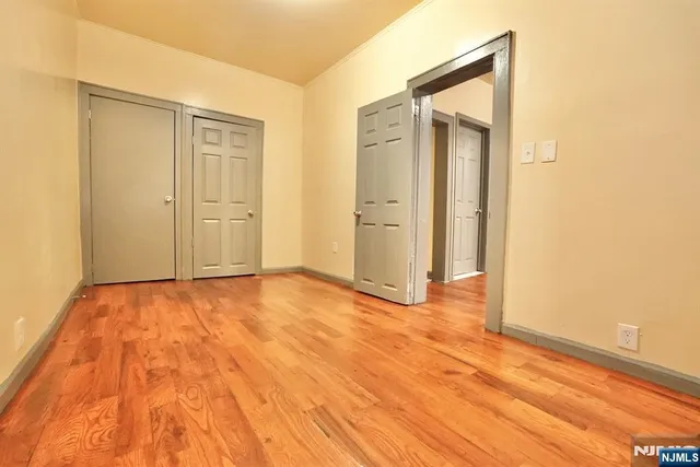 an empty room with wooden floor and closet