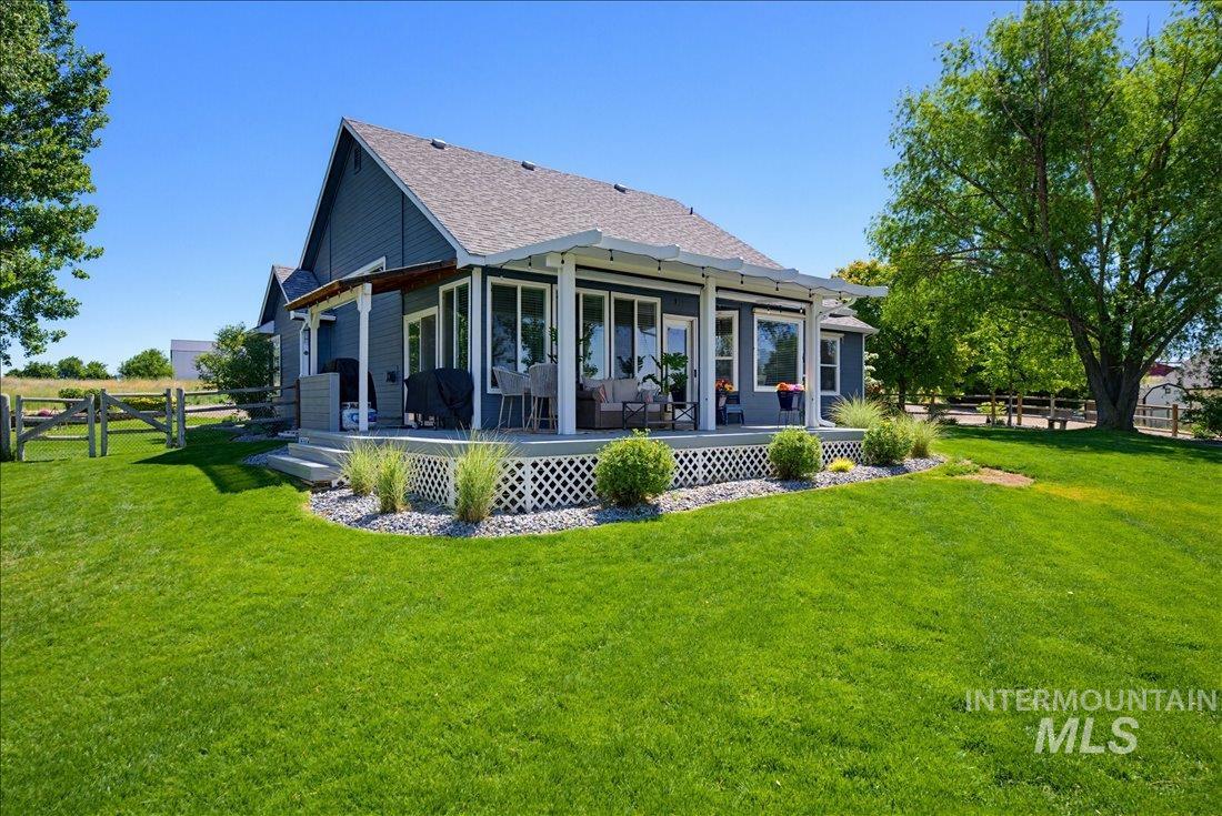 24623 Falcon Lane Caldwell, ID 83607 - Photo 25 of 40 Expansive green lawn bordering a covered outdoor patio with white railings