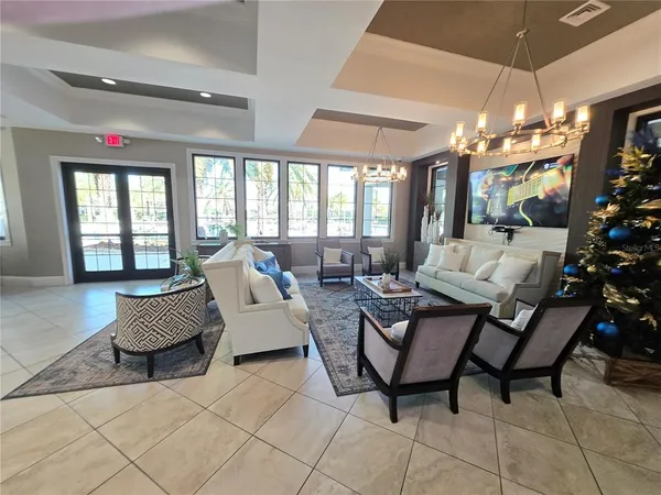 a living room with patio furniture and a chandelier
