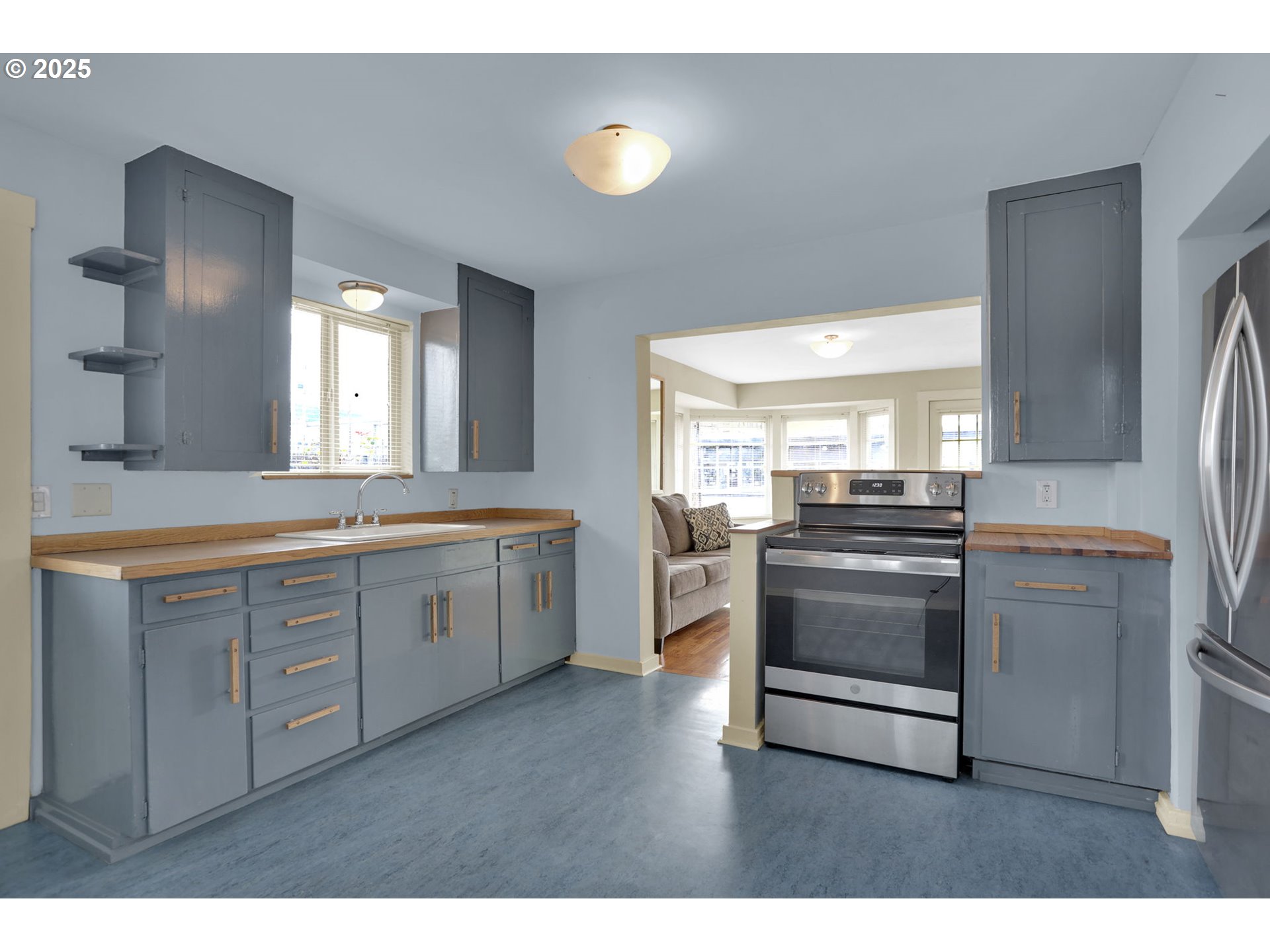 728 East Whiteaker Avenue Cottage Grove, OR 97424 - Photo 11 of 38 a kitchen with stainless steel appliances a sink cabinets and wooden floor