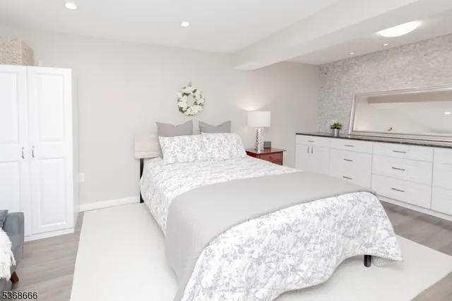 a bedroom with a bed and a lamp on dresser