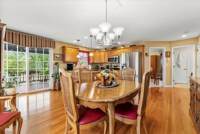 a view of a dining room with furniture a chandelier and wooden floor