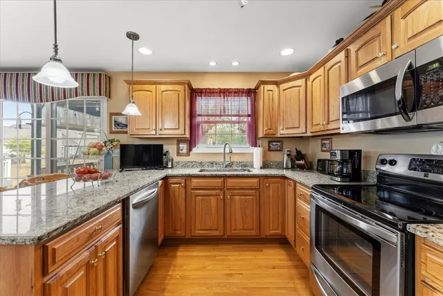 a kitchen with stainless steel appliances granite countertop a stove sink and cabinets