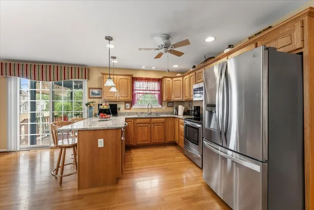 a kitchen with stainless steel appliances granite countertop a refrigerator a sink dishwasher a stove and a refrigerator