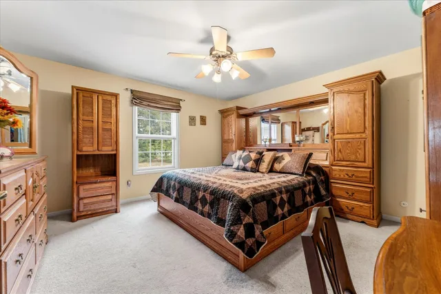 a bed sitting in a spacious bedroom next to a window
