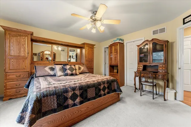 a bedroom with a bed lamps and chairs