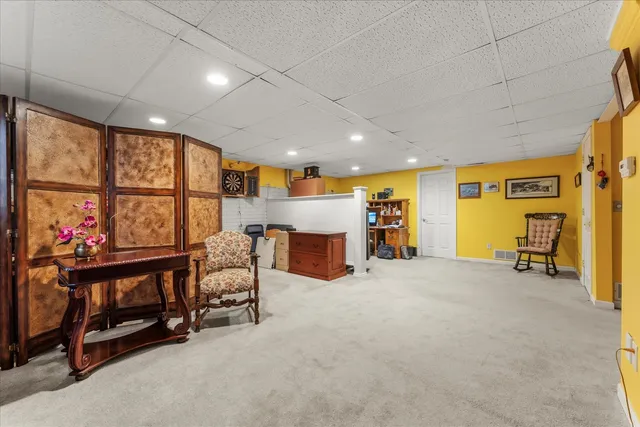 a view of an empty room with furniture and a window