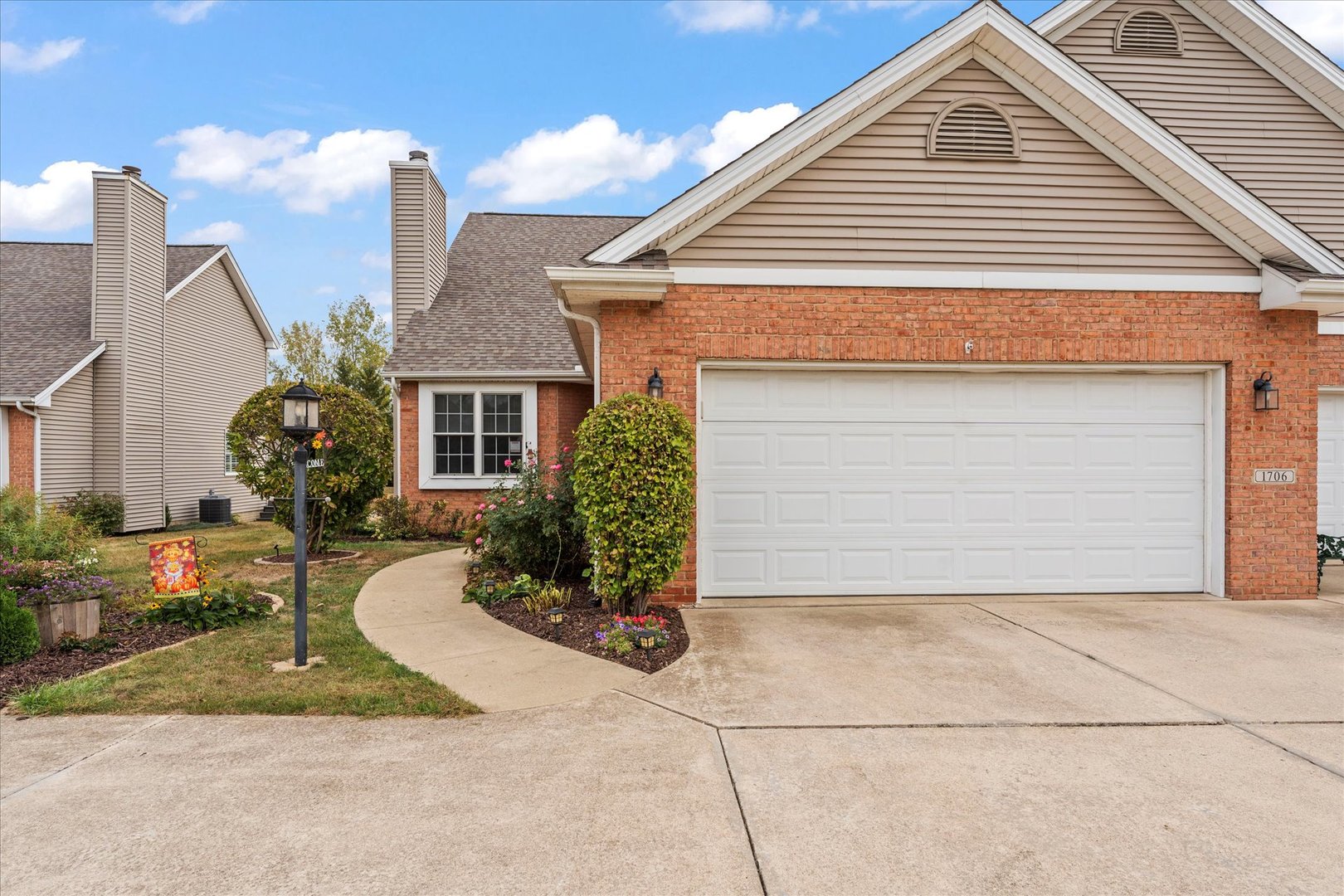 1706 Tin Cup Road, Unit 1706 Mahomet, IL 61853 - Photo 42 of 43 a front view of a house with a yard and garage