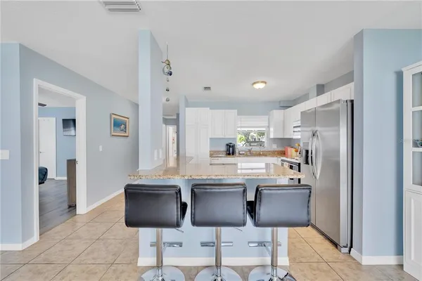 a kitchen with stainless steel appliances granite countertop a refrigerator and a stove top oven