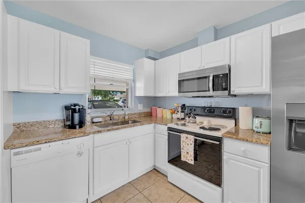 a kitchen with cabinets stainless steel appliances a sink and a counter space