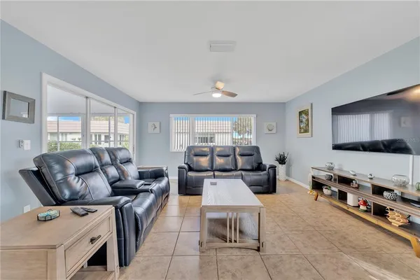 a living room with furniture a flat screen tv and a window