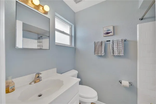 a bathroom with a sink mirror and toilet