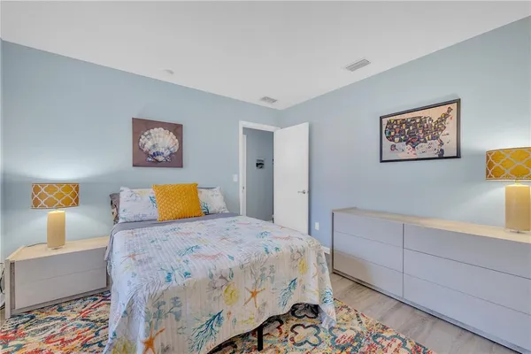 a bedroom with a bed and paintings on the wall