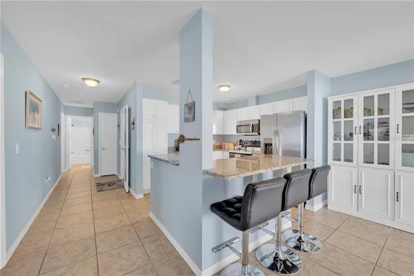 a kitchen with stainless steel appliances kitchen island granite countertop a refrigerator and cabinets