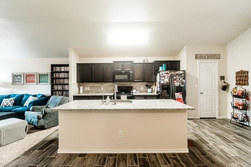 7426 103rd Street Lubbock, TX 79424 - Photo 7 of 10 a large white kitchen with wooden floor