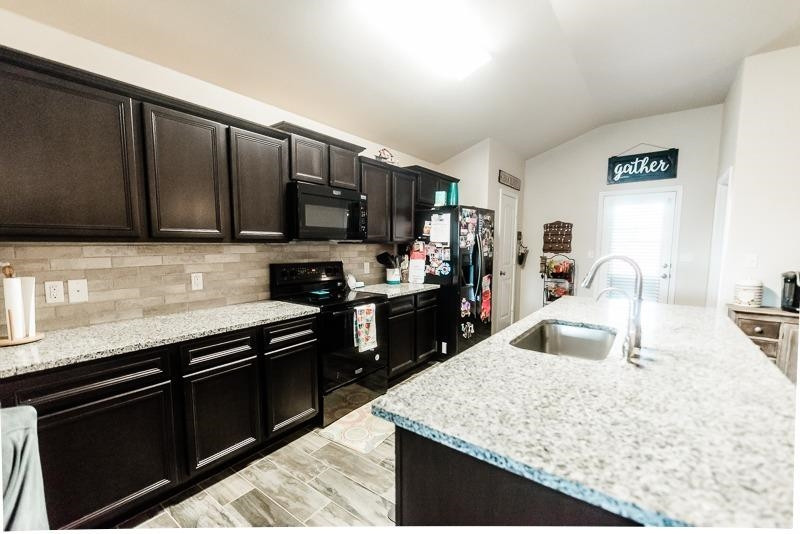 7426 103rd Street Lubbock, TX 79424 - Photo 9 of 10 a kitchen with stainless steel appliances granite countertop a sink stove and refrigerator