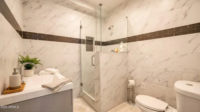 a bathroom with a granite countertop sink a toilet and shower