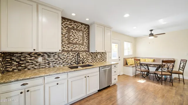 a view of a kitchen with granite countertop stainless steel appliances a sink and cabinets