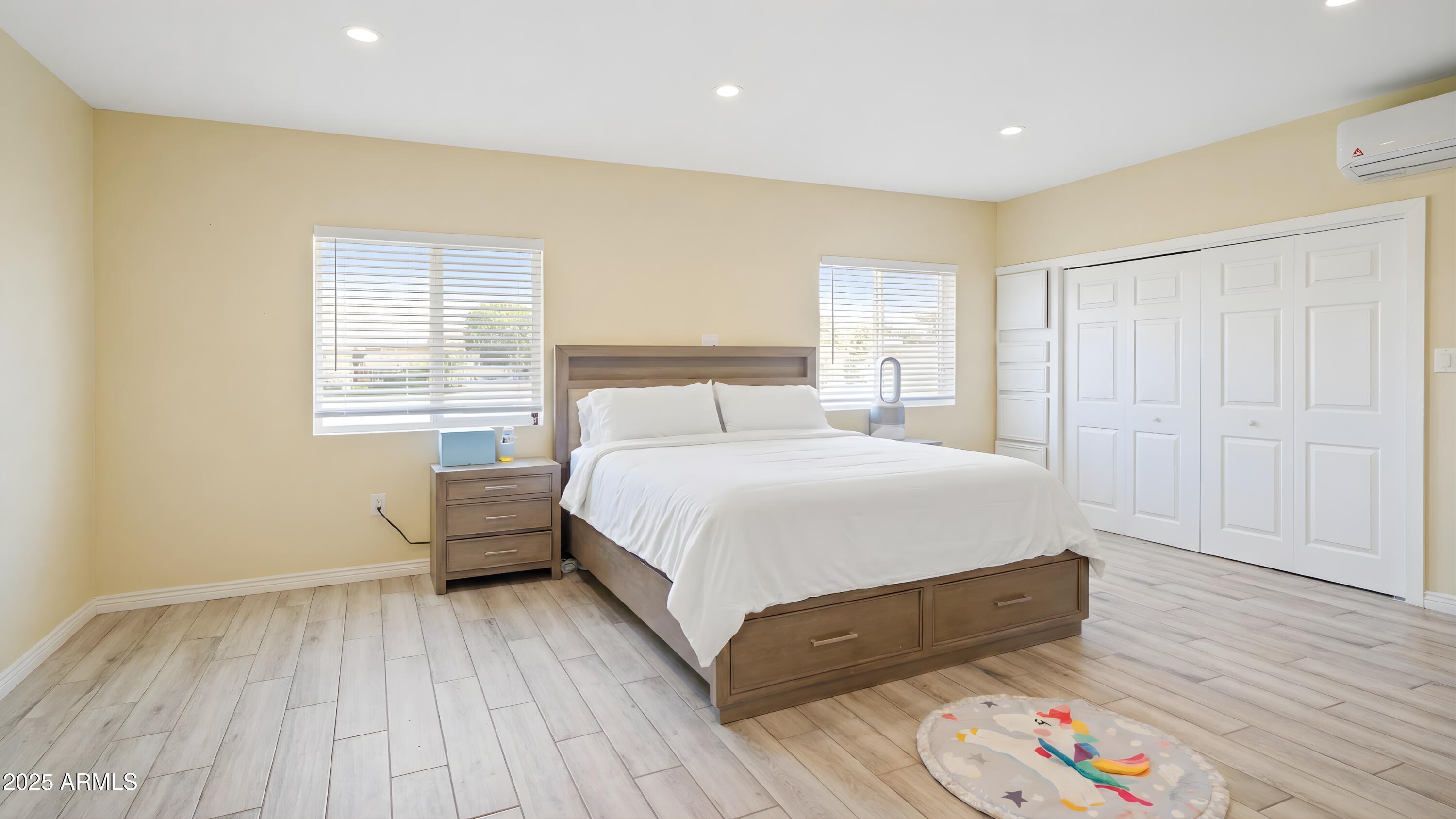 945 East Missouri Avenue Phoenix, AZ 85014 - Photo 7 of 15 a bedroom with a bed and wooden floor