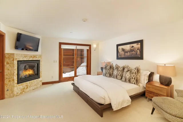 a spacious bedroom with a bed and glass window