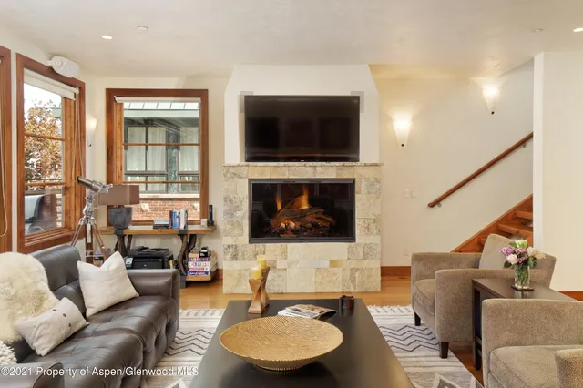 a living room with furniture flat screen tv and a fireplace