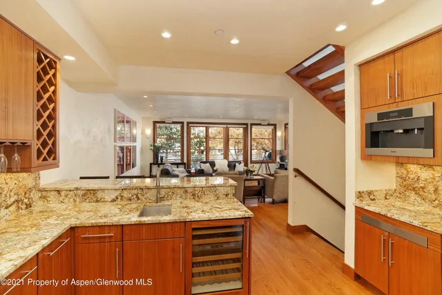 a view of a kitchen with a sink and dishwasher with wooden floor