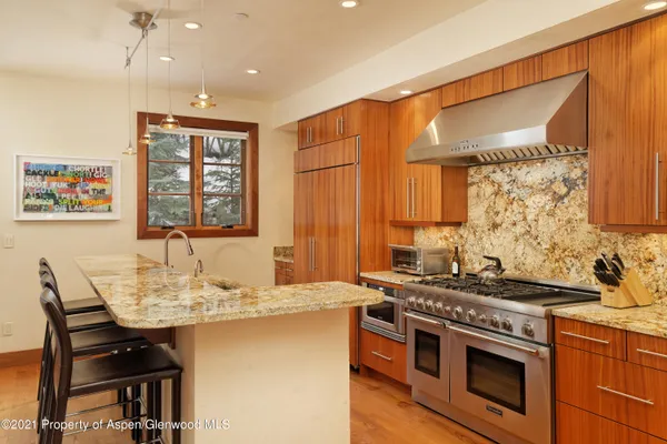 a kitchen with stainless steel appliances granite countertop a stove a sink and a microwave