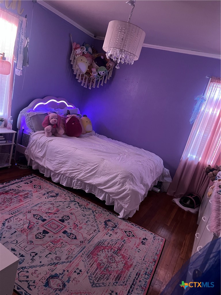 2418 Osage Road Gatesville, TX 76528 - Photo 12 of 15 a bedroom with a bed mirror and a lamp on dresser