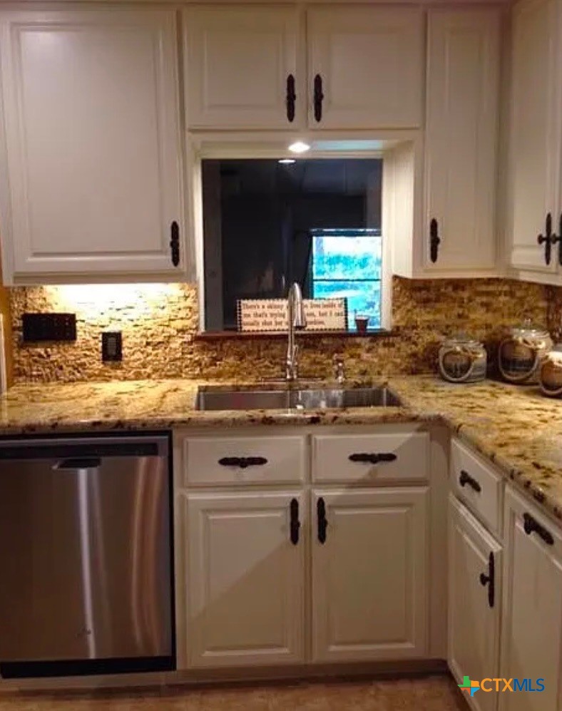 2418 Osage Road Gatesville, TX 76528 - Photo 5 of 15 a kitchen with granite countertop a sink and cabinets