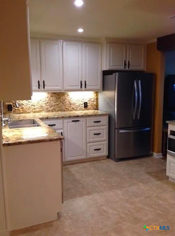2418 Osage Road Gatesville, TX 76528 - Photo 6 of 15 a kitchen with granite countertop a refrigerator and a stove top oven