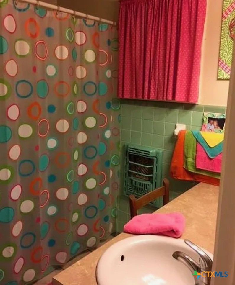 2418 Osage Road Gatesville, TX 76528 - Photo 7 of 15 a bathroom with a sink toilet and curtain